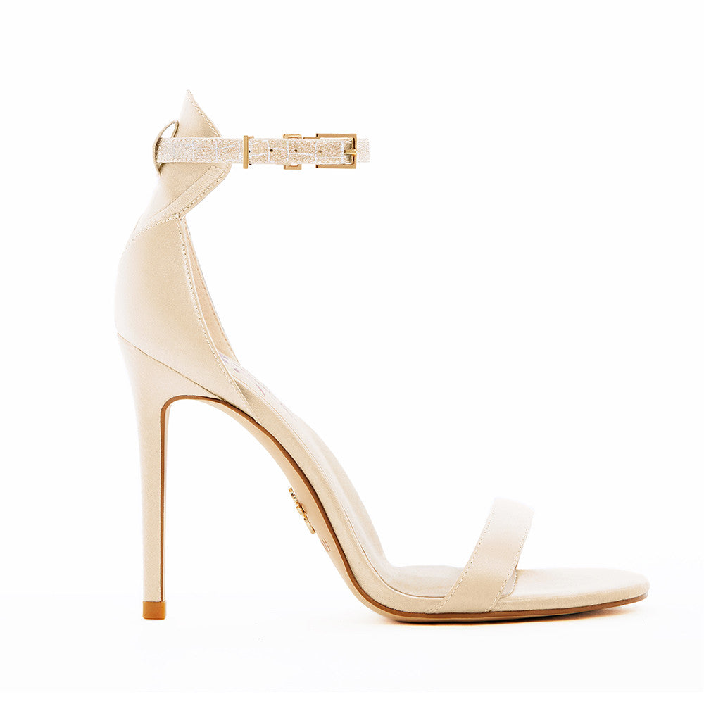 Elegant gold high-heeled vegan silk sandal, featuring a minimalist ankle strap, and open-toe design, perfect for sophisticated and stylish occasions.