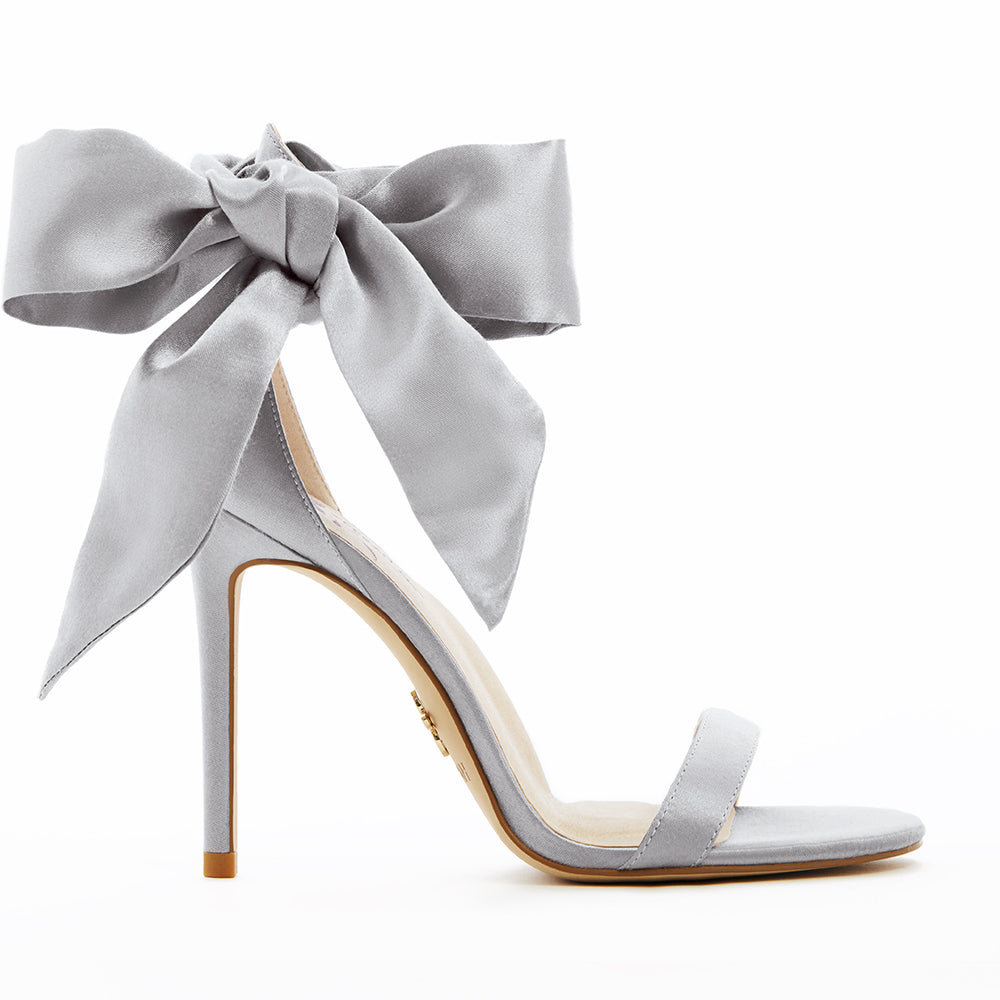 Elegant silver high-heeled vegan sandal, featuring a statement vegan silk-satin bow, sleek ankle strap, and minimalist open-toe design, perfect for sophisticated and stylish occasions.