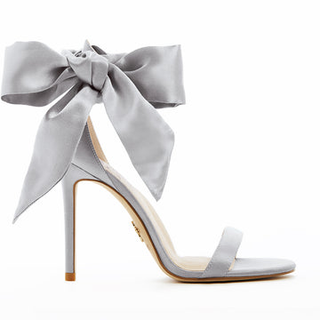 Elegant silver high-heeled vegan sandal, featuring a statement vegan silk-satin bow, sleek ankle strap, and minimalist open-toe design, perfect for sophisticated and stylish occasions.